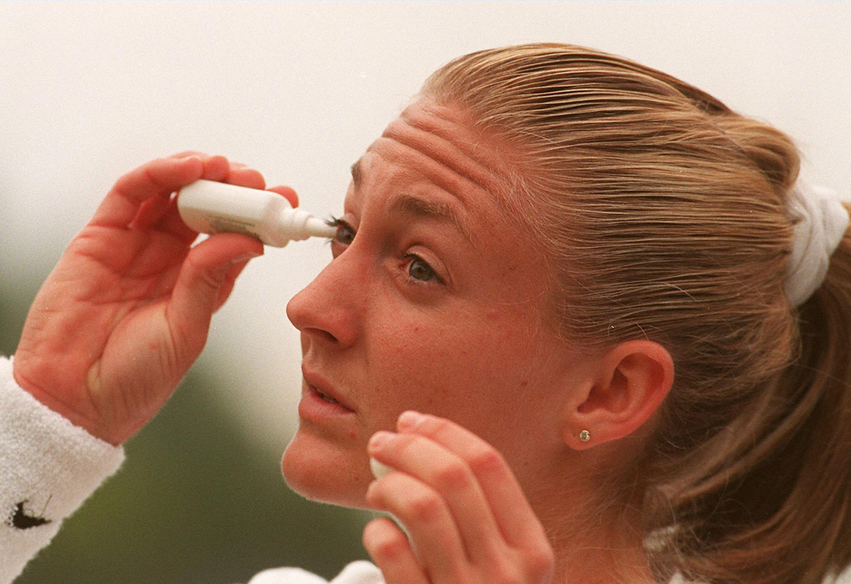 An athlete puts in eye drops.