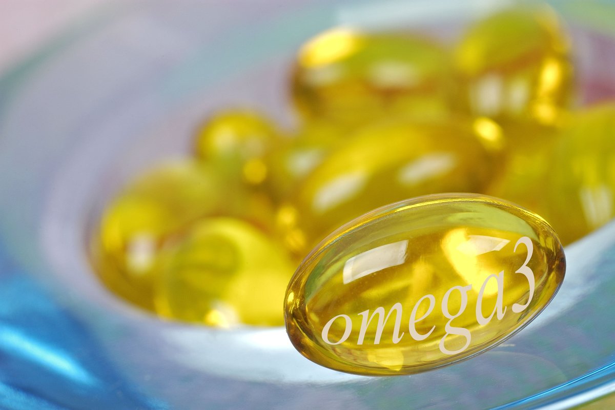 Golden omega-3 supplement capsules are seen.