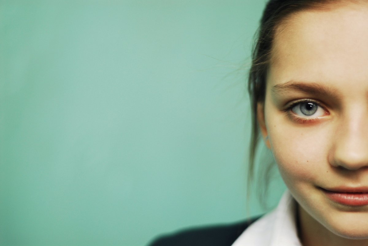Half of a blue-eyed teenager girl's face is seen.