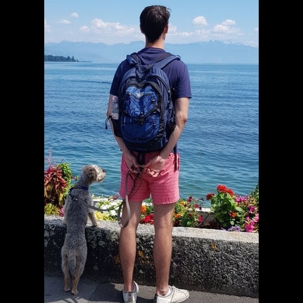 man and dog stare out across the water together