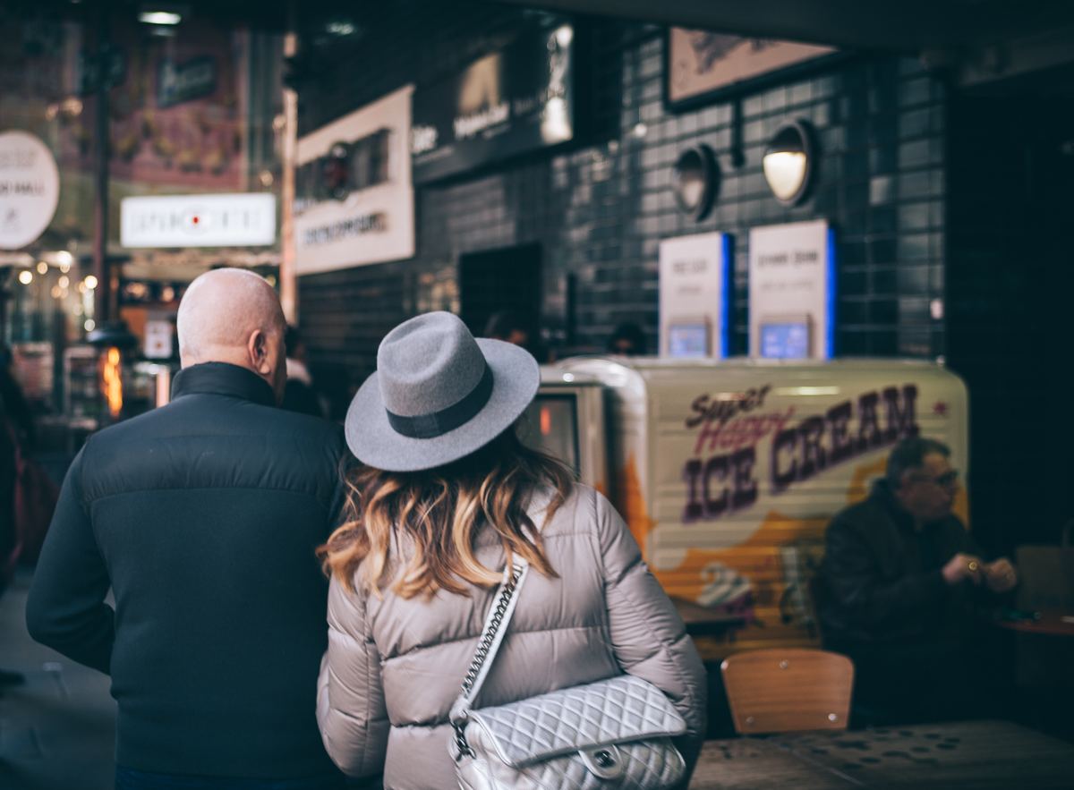 woman and man facing away from camera getting ice cream