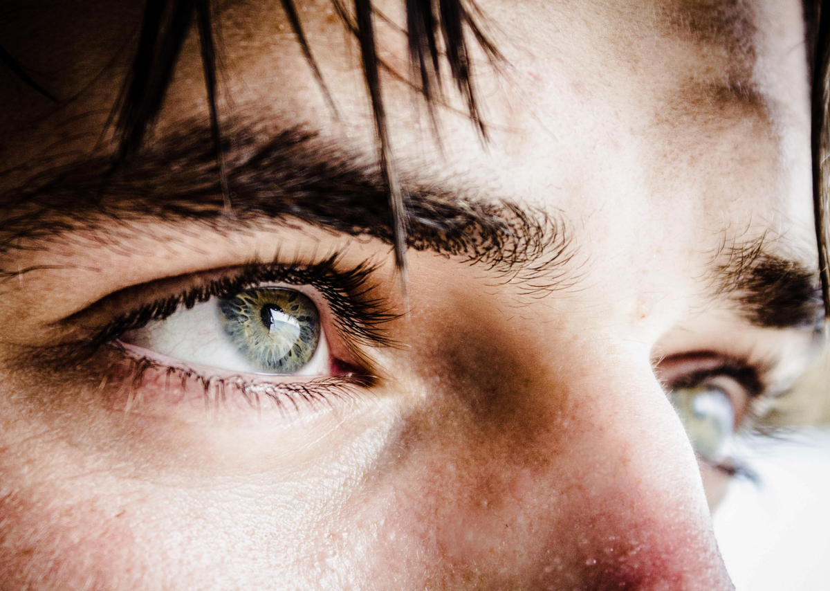 A close-up shows a man's almond-shaped eyes.