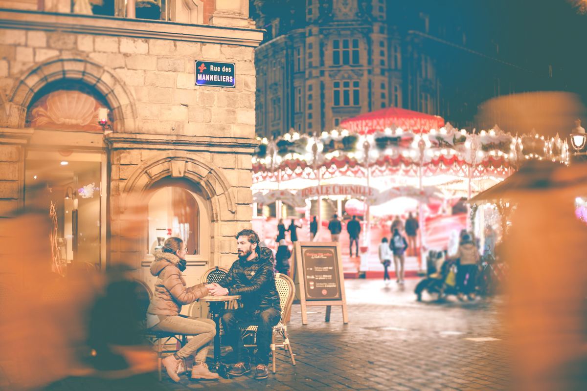 couple sitting together at a table with carousel nearby