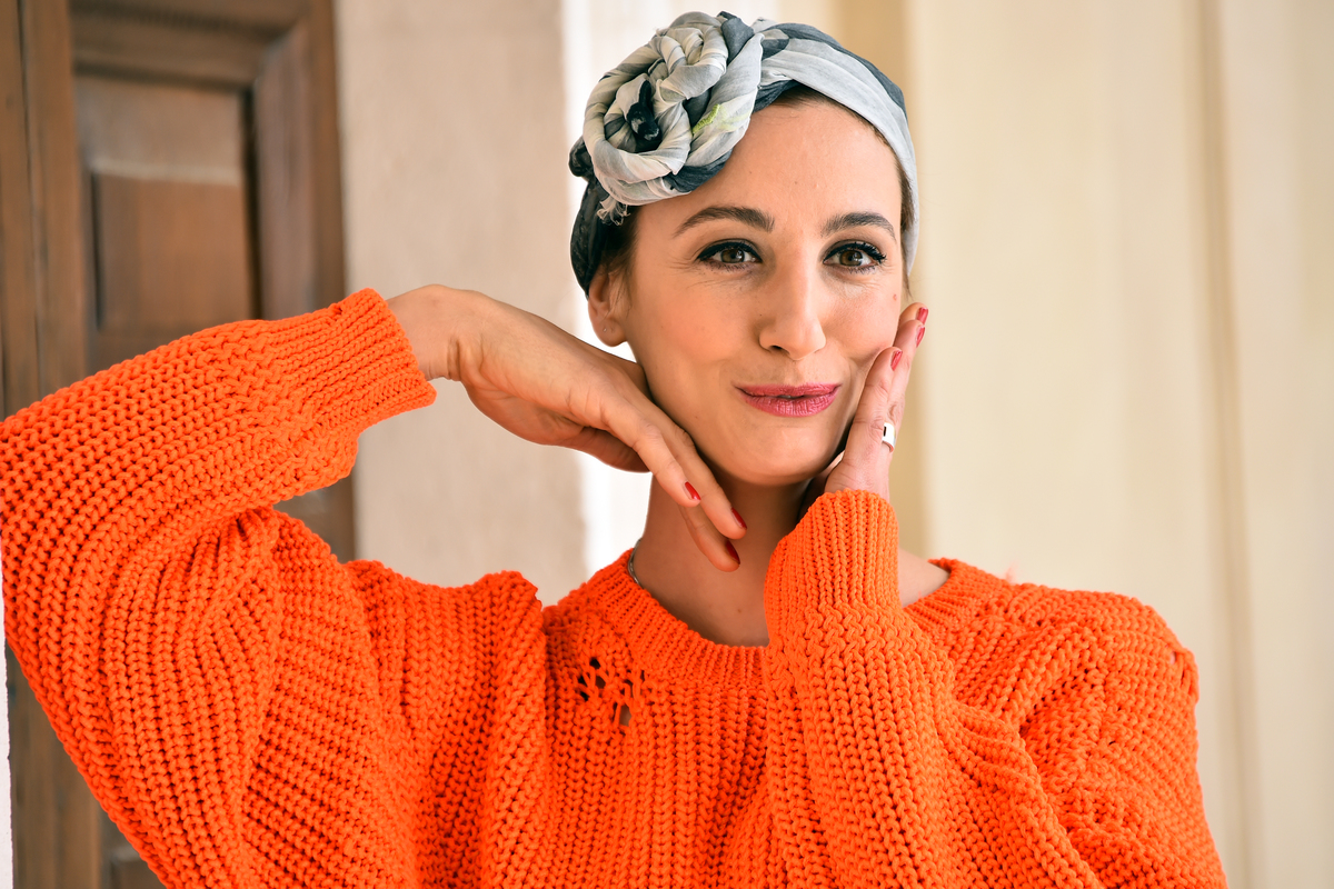 An Italian actress touches her face.