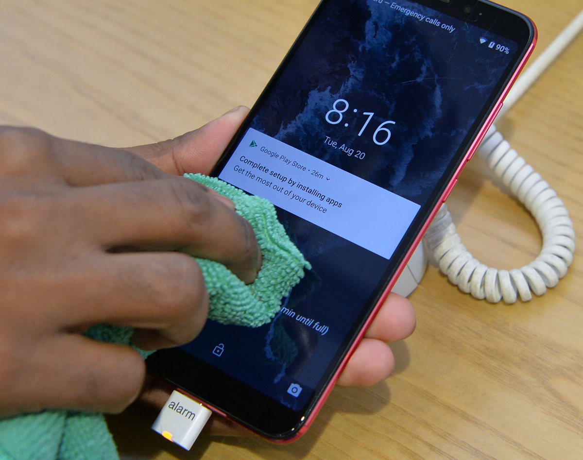 A person cleans their phone with a cloth.