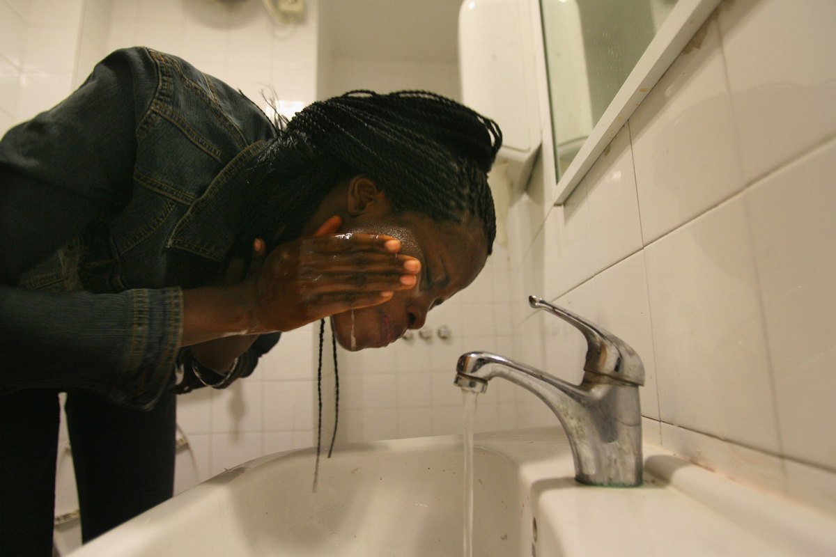 A Nigerian fashion model washes her face.