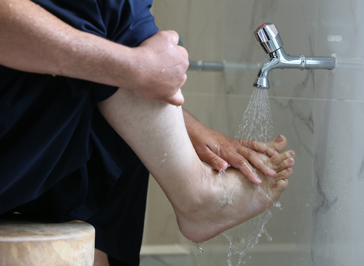 A man washes his feet before entering a mosque.