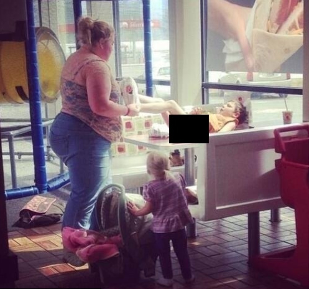 woman changes child's diaper on mcdonalds booth table