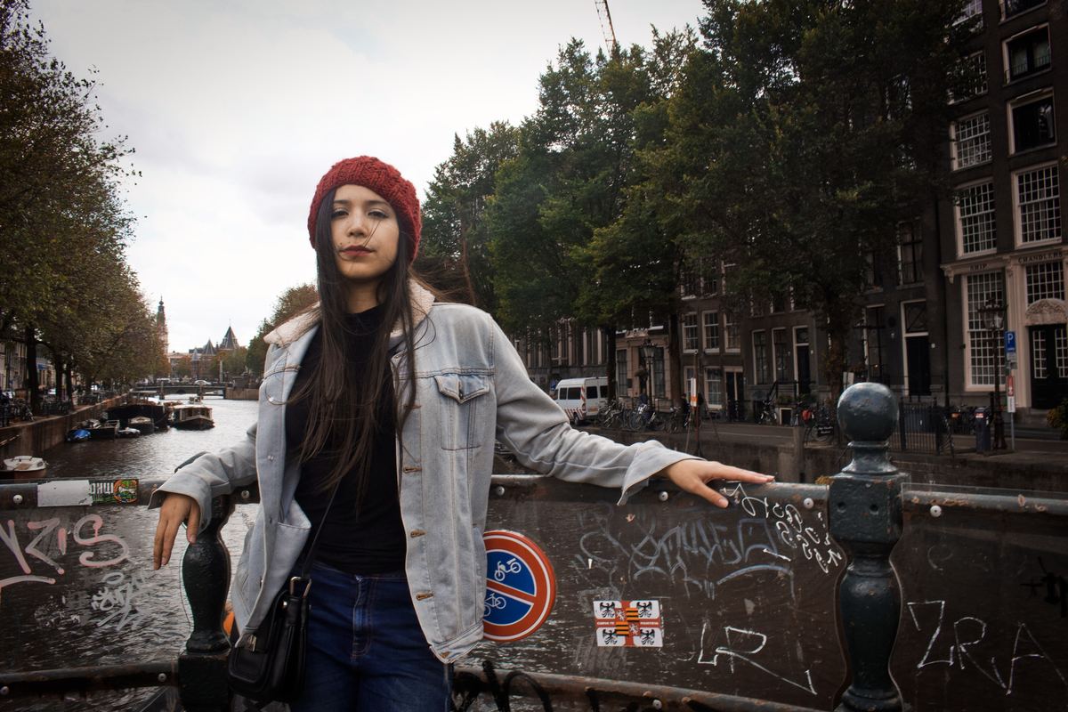 a woman standing on a bridge in amsterdam