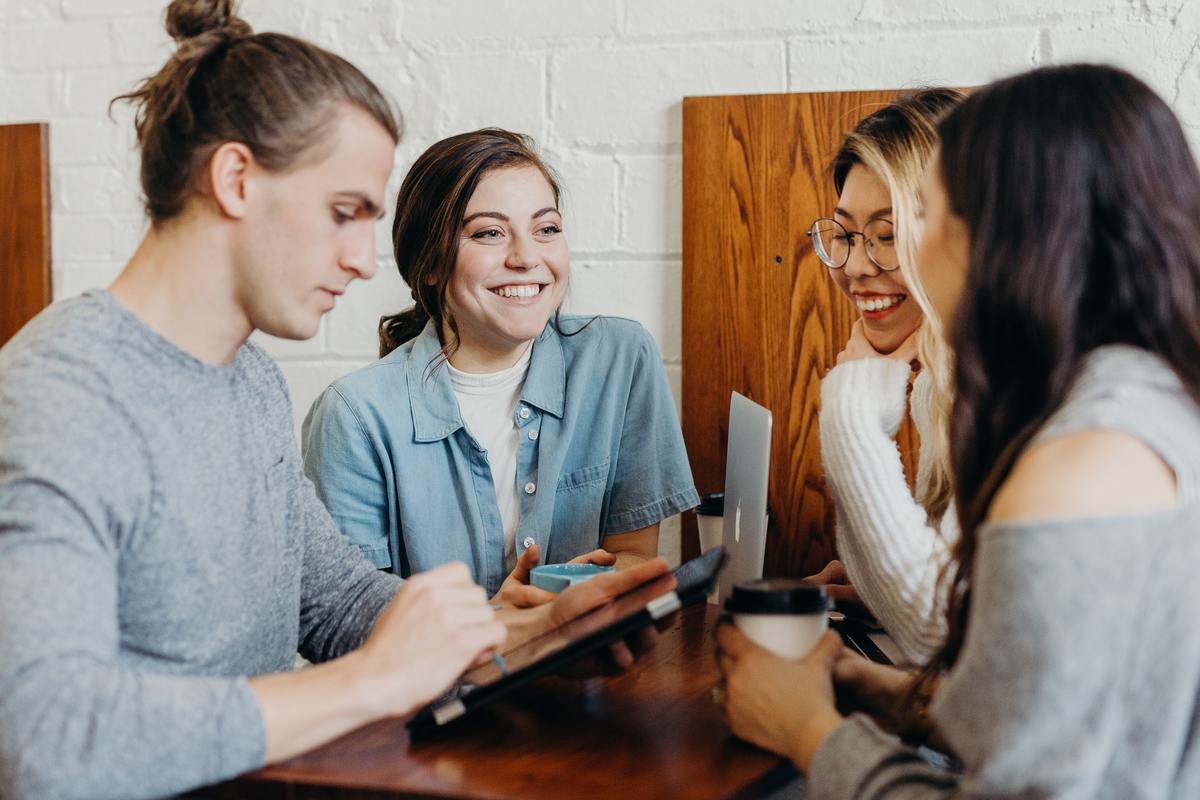 friends talking in coffee shop some smiling