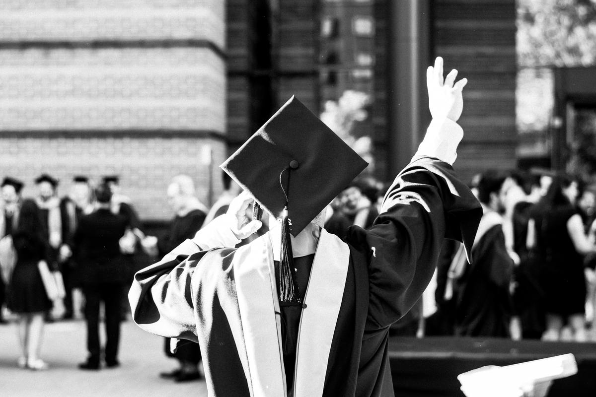 greyscale photo of person at convocation