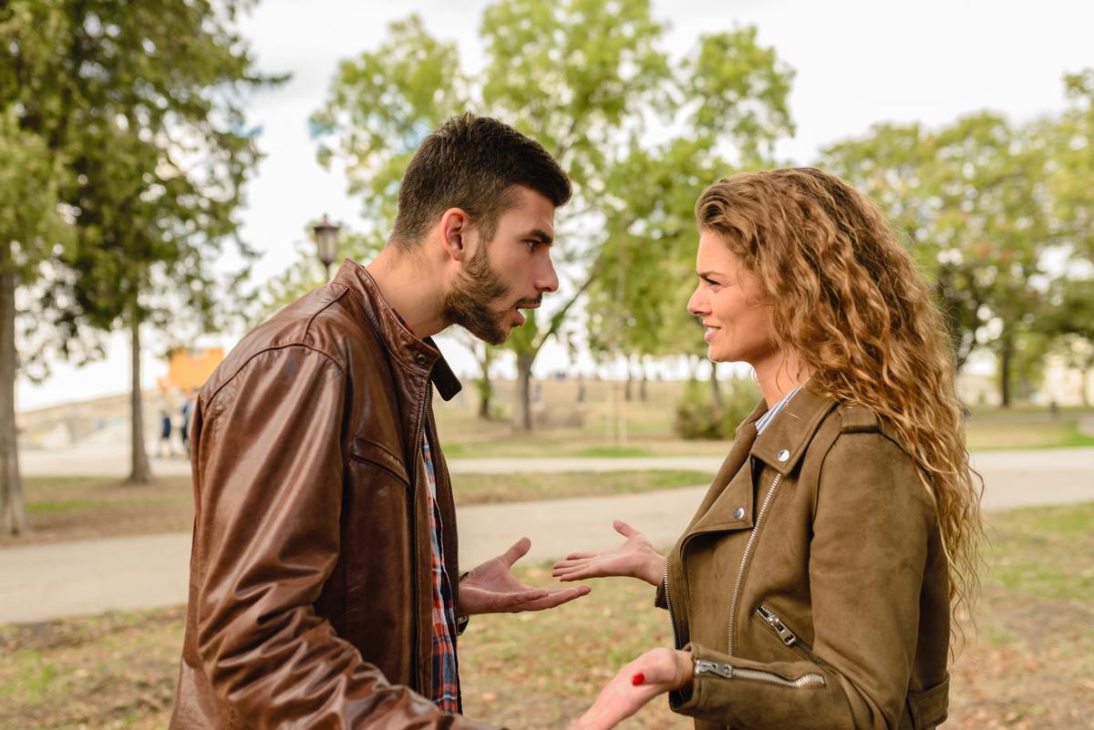 man and woman arguing outside in brown jackets
