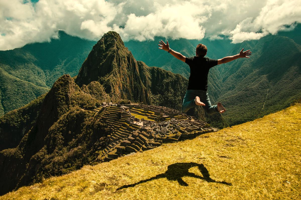 a man leaping in front of machu picchu in peru