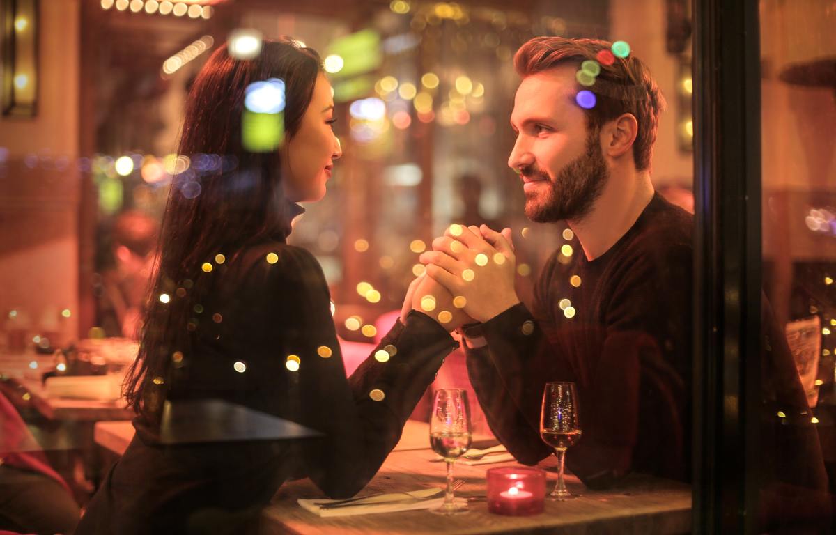 couple holding hands in restaurant