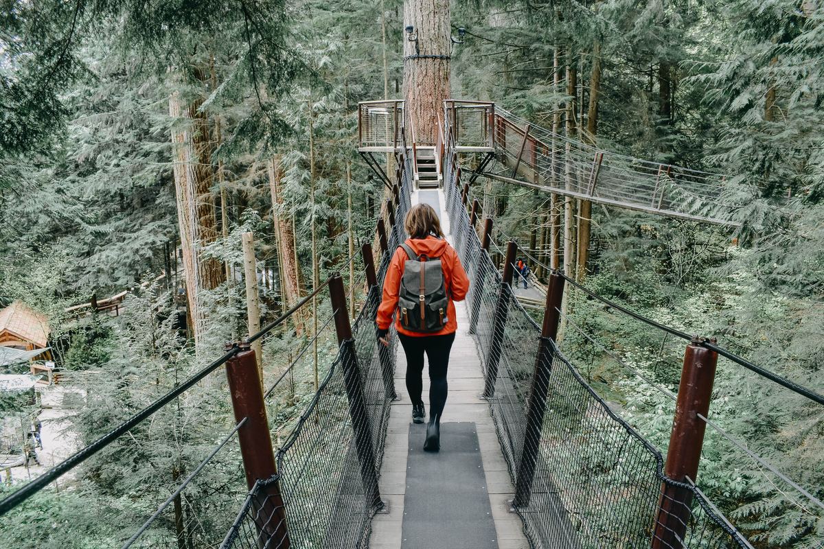 a woman walking on a bridge in vancouver