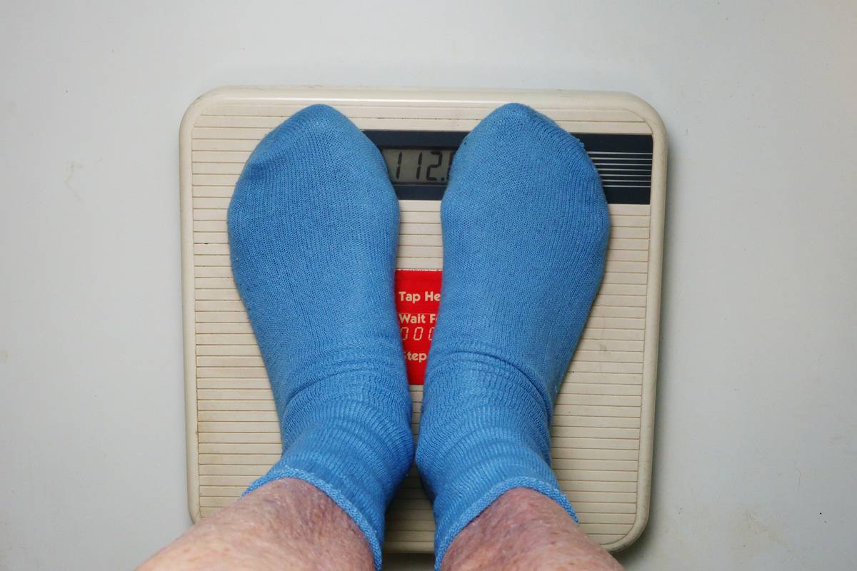 A man steps on a scale.