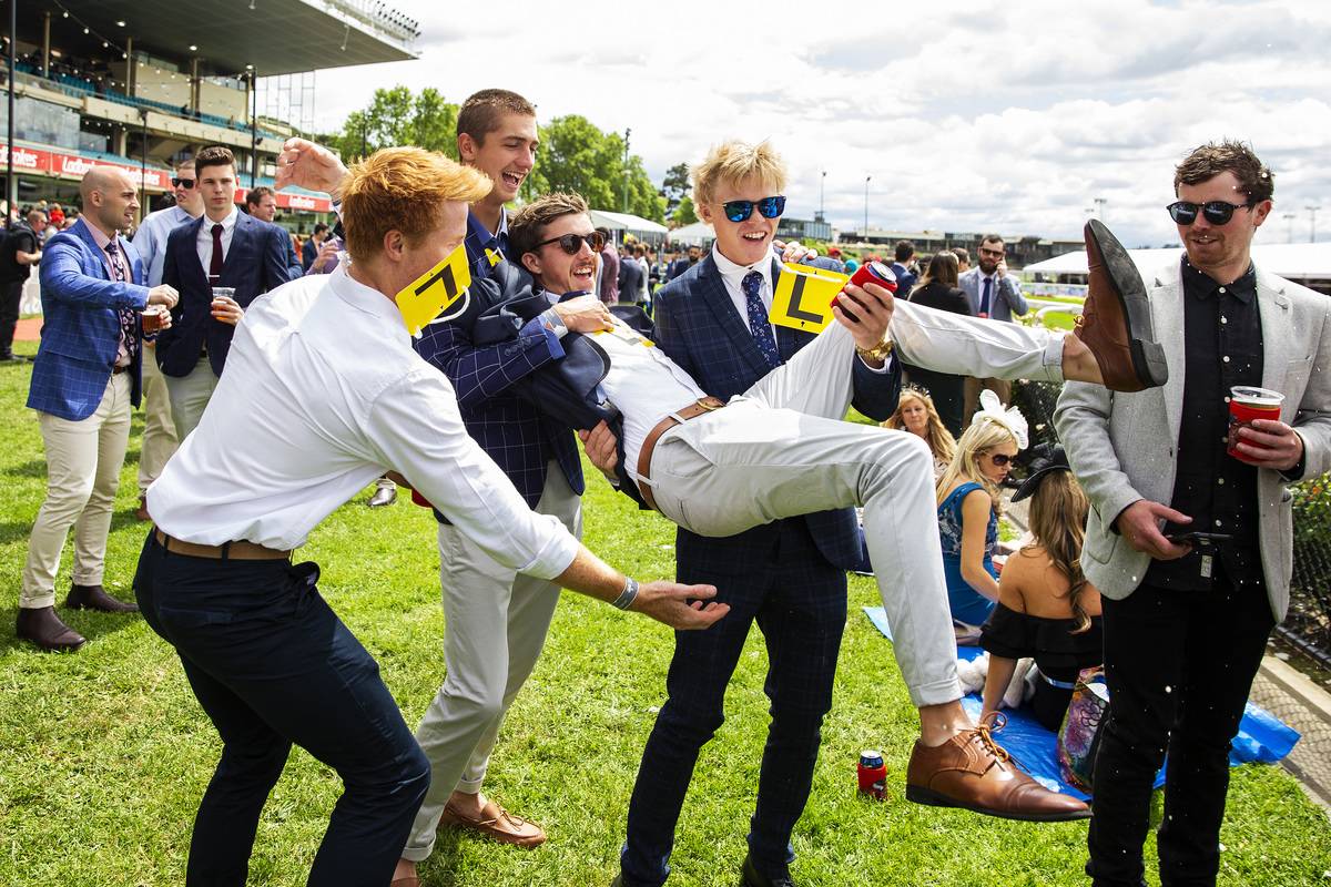 group of young guys lifting their one friend up at an event