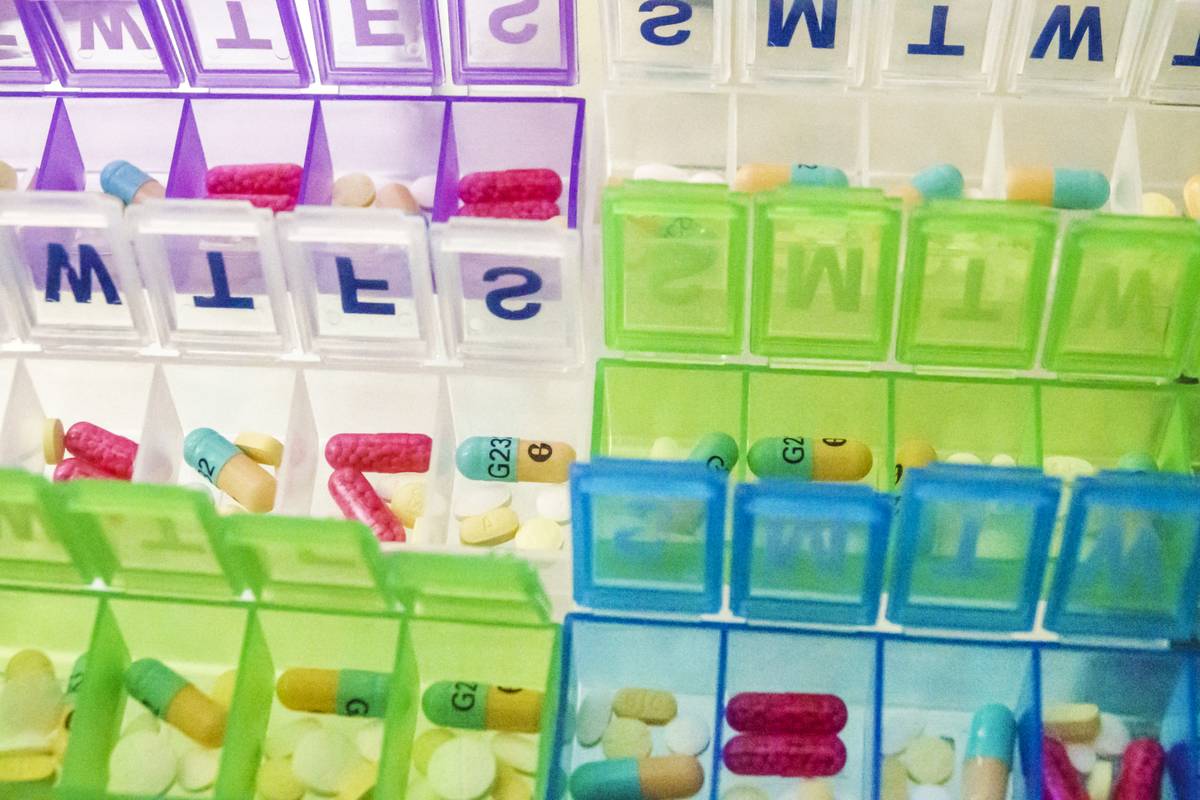 A pill organizer contains vitamins and medication for each day of the week.