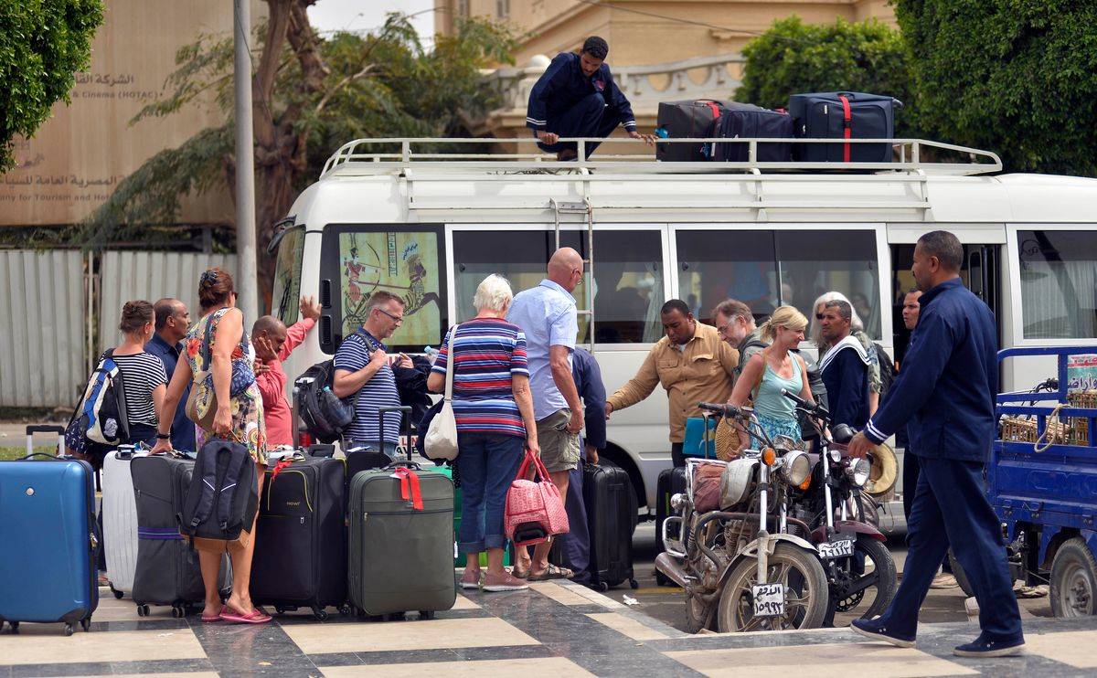 TRAVELERs with luggage boarding shuttle bus