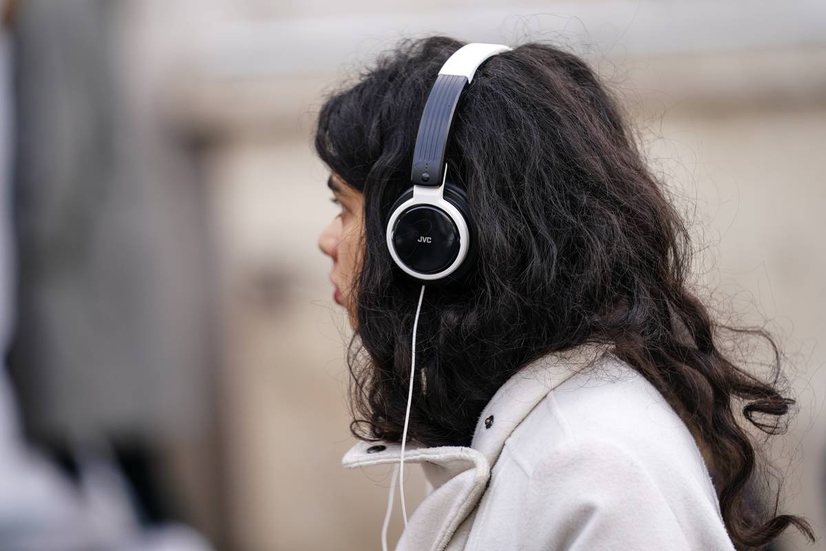 A woman listens to music using headphones.