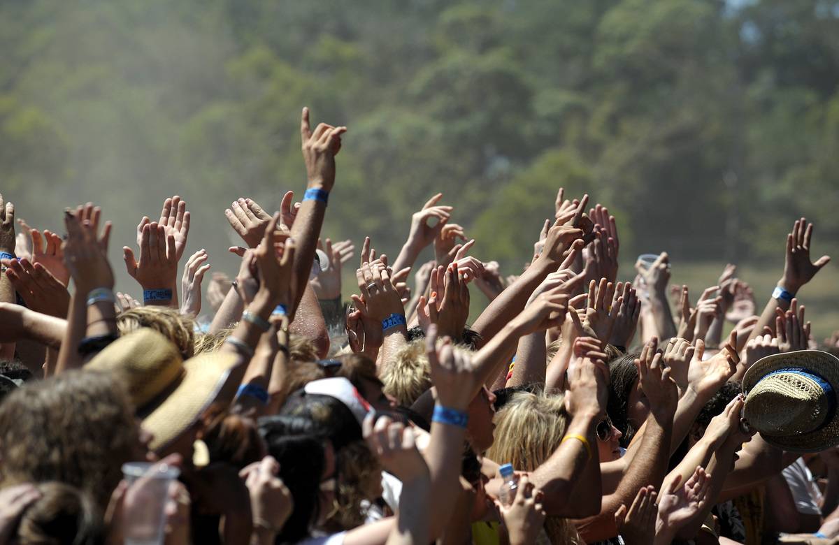 crowd of people with hands up wearing wristbands