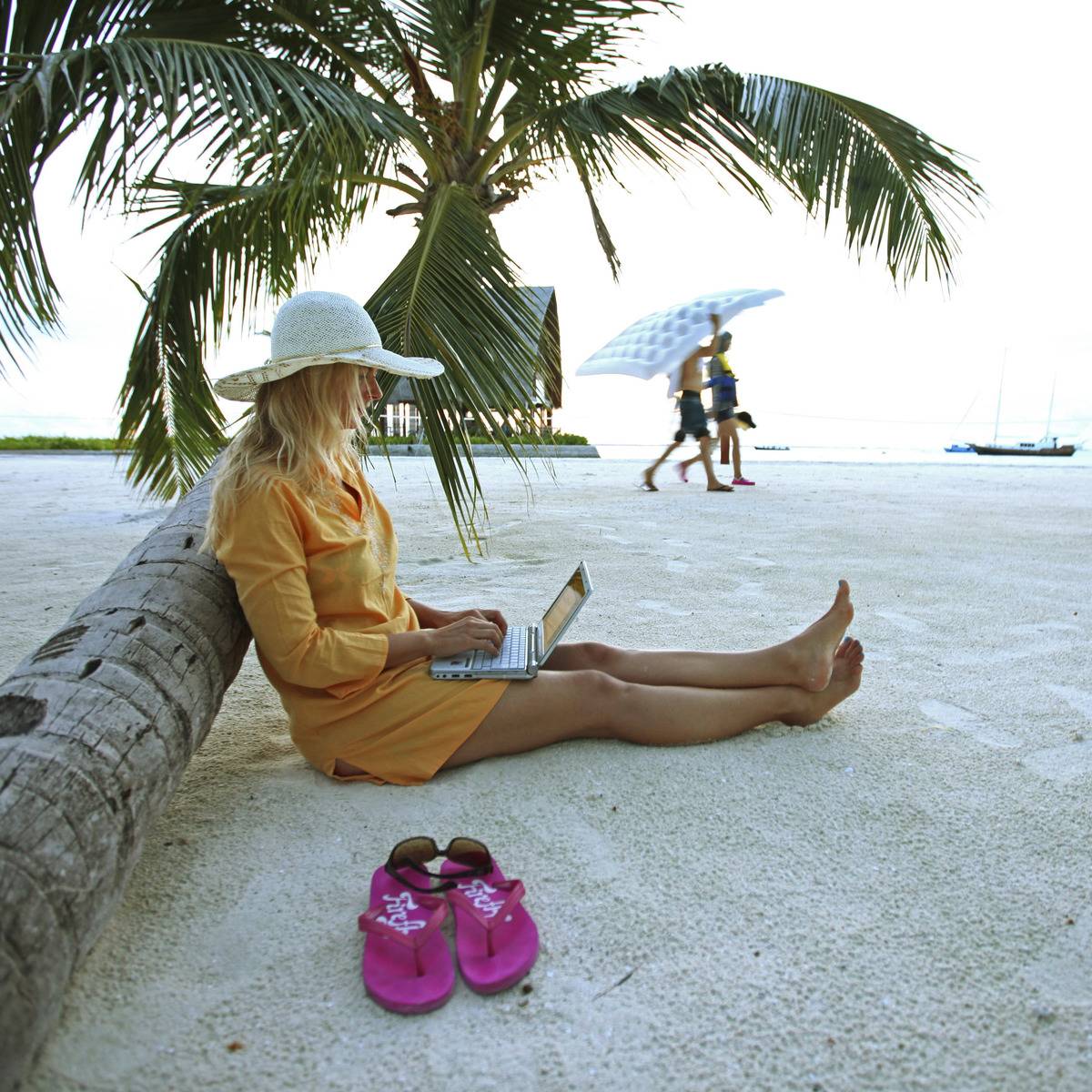 girl on laptop by beach