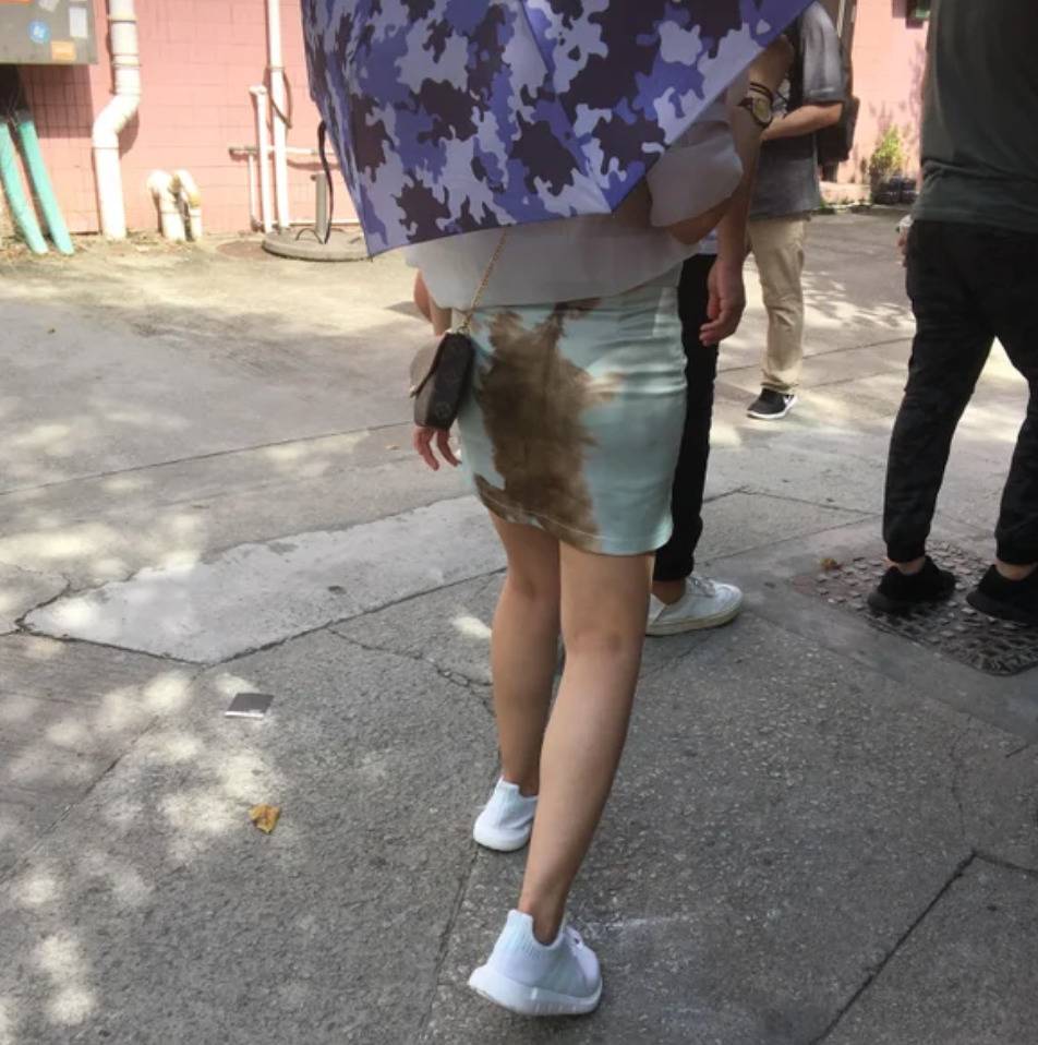 blue dress with brown design down the back makes woman look like she soiled herself