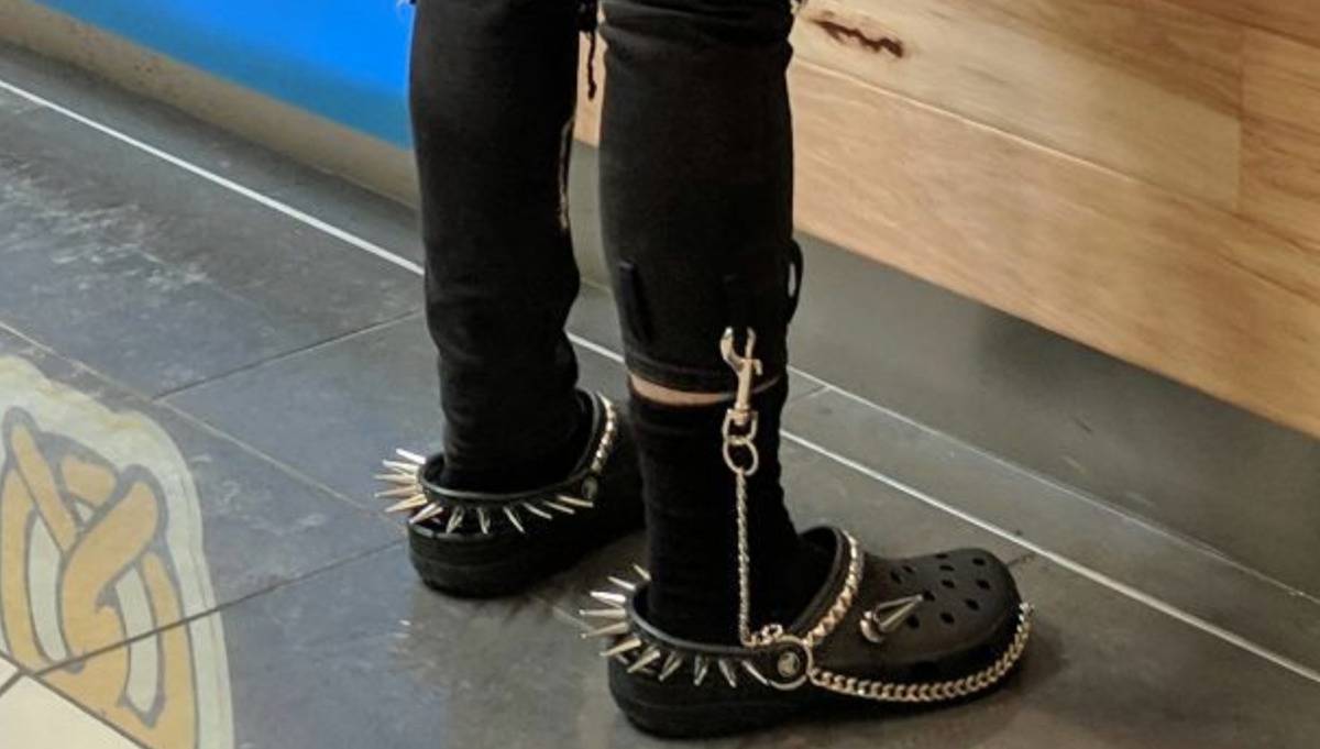 crocs with spikes and a chain attaching them to pant leg