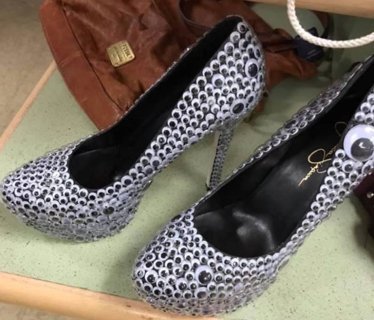 pair of high heels entirely covered in googly eyes