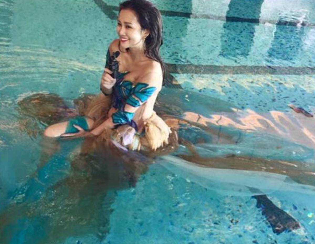woman wearing brown dress in pool looks like she had a bowel-related accident