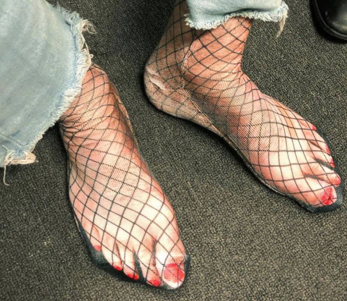 socks have the image of feet in fishnets printed on them