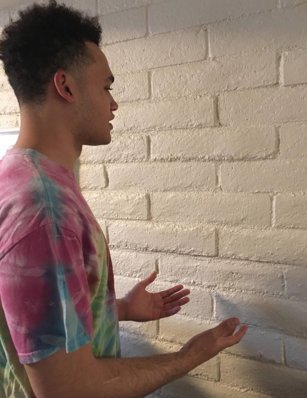 man posed like he's talking to a brick wall