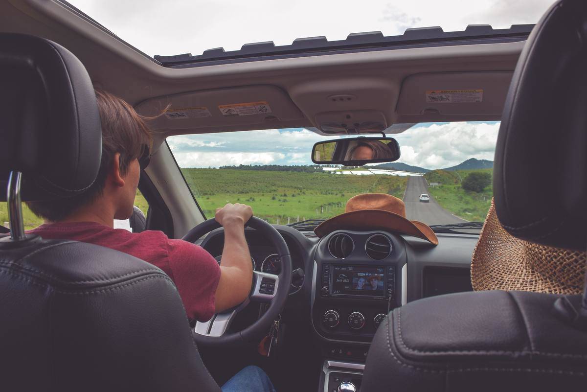 man driving jeep on road trip with passenger