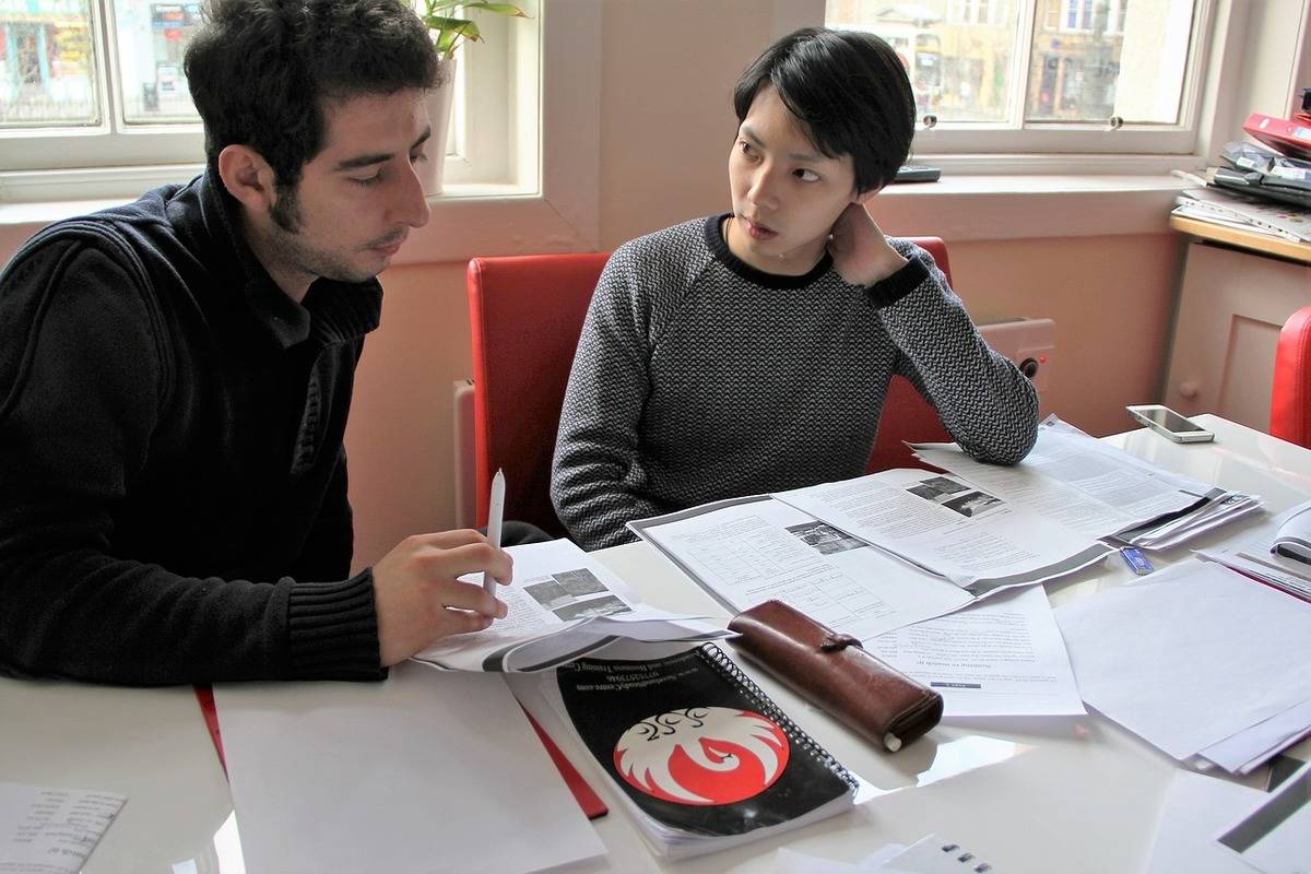 An instructor teaches a second language to a student.