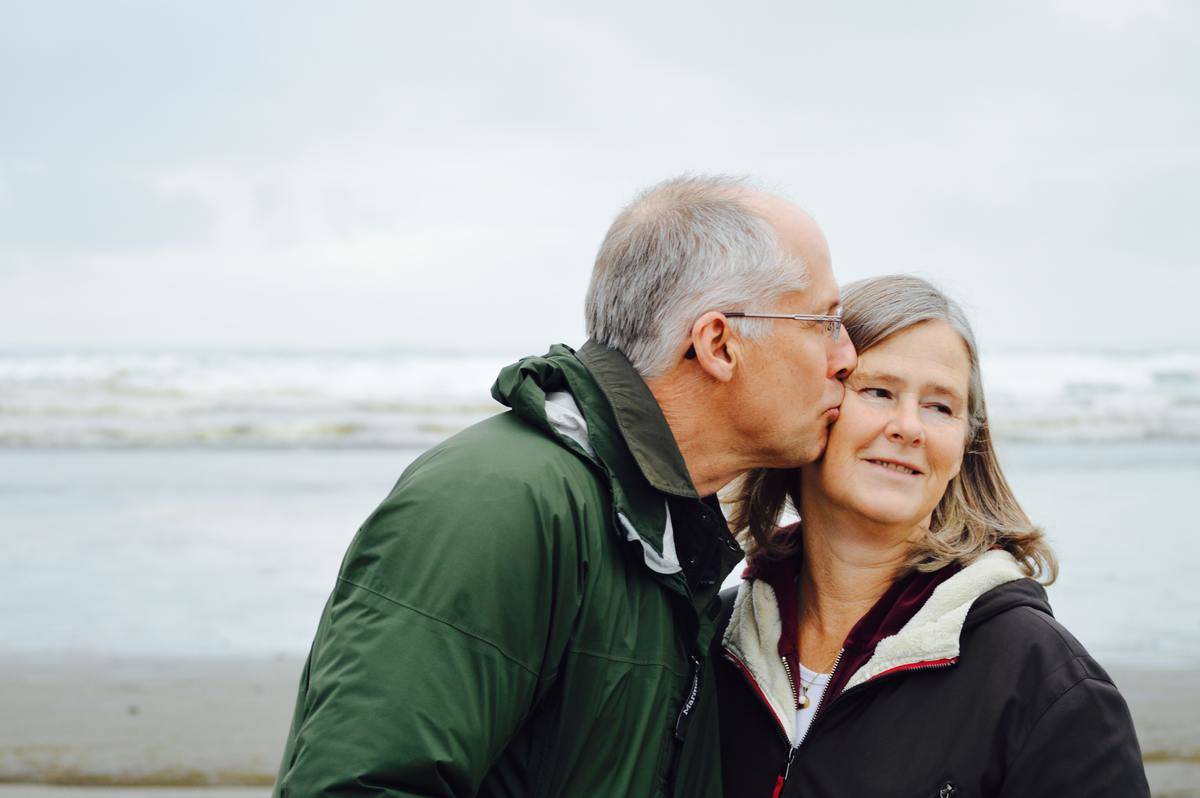 middle aged man kissing wife on cheek