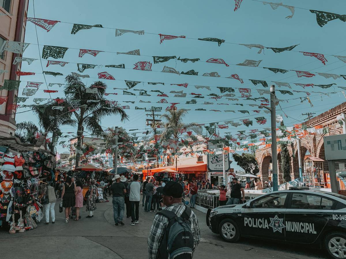 a busy street with a police car in tijuana, mexico