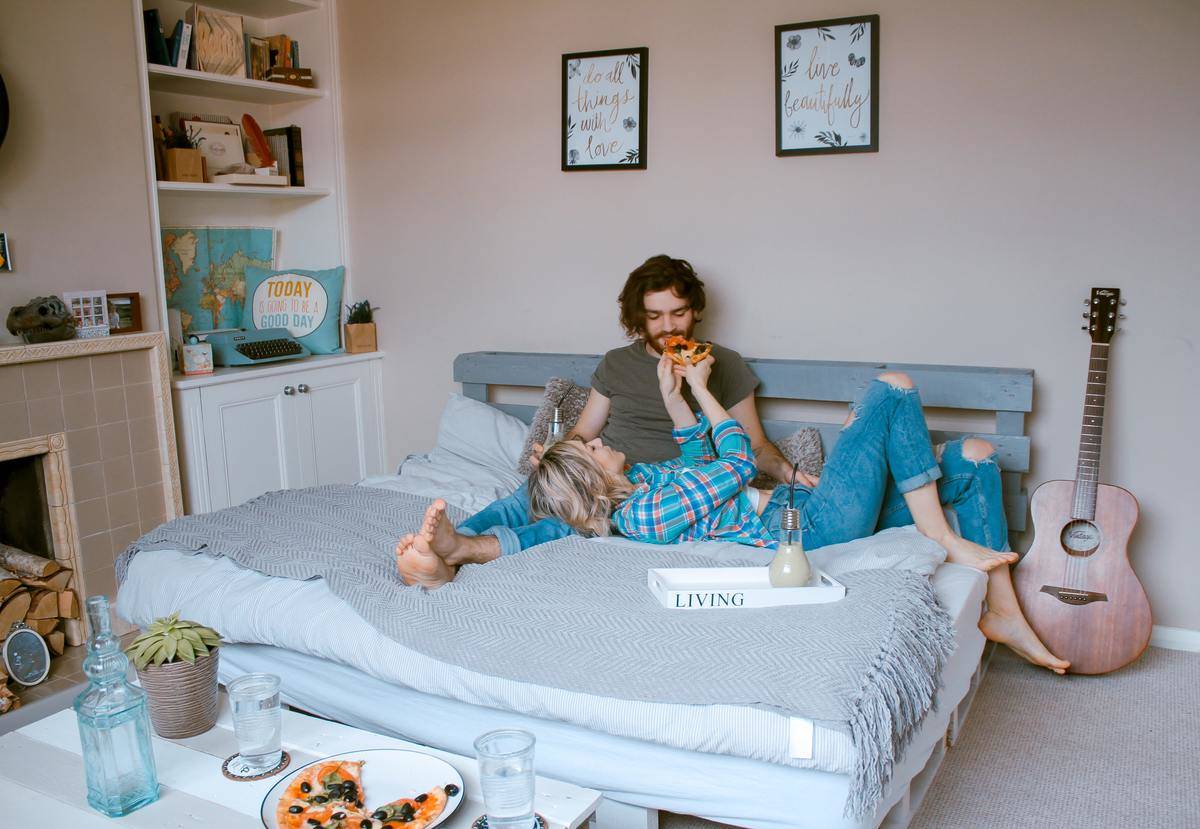 man with messy hair with girl lounging in bed