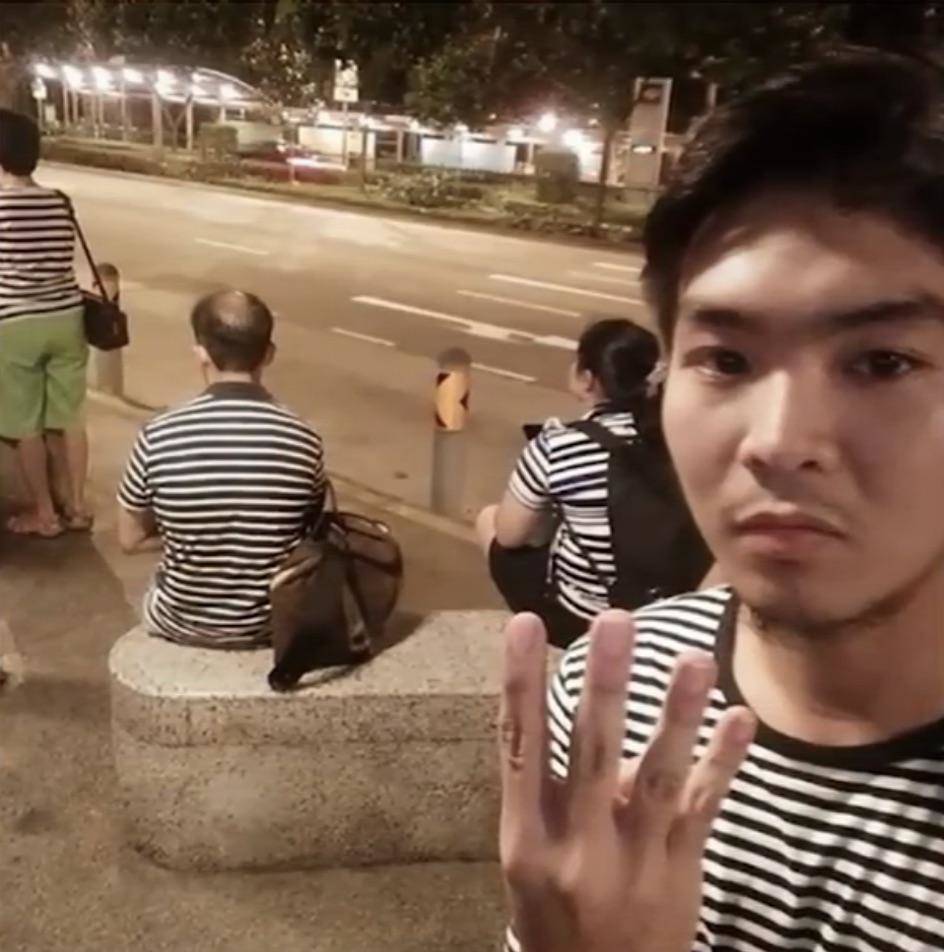 four strangers at bus stop all wearing the same shirt
