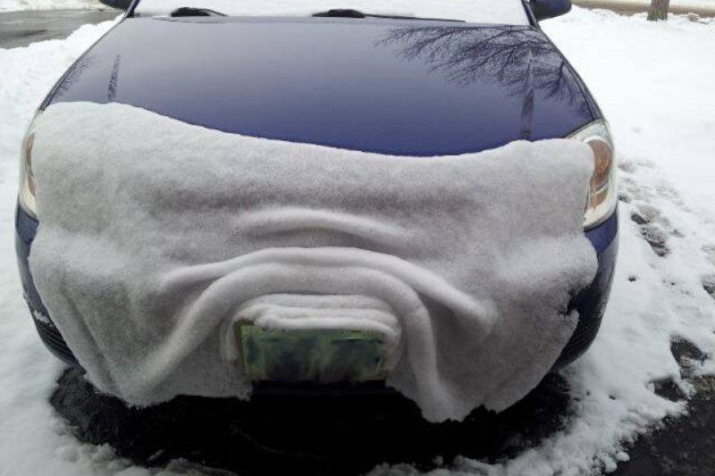 snow looks like a blanket on a car