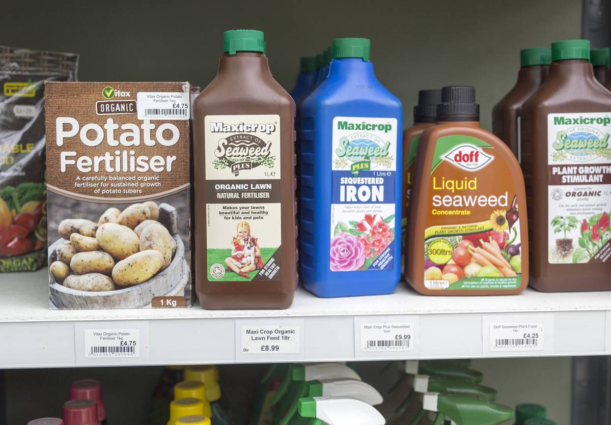 A shelf is lined with fertilizer products.