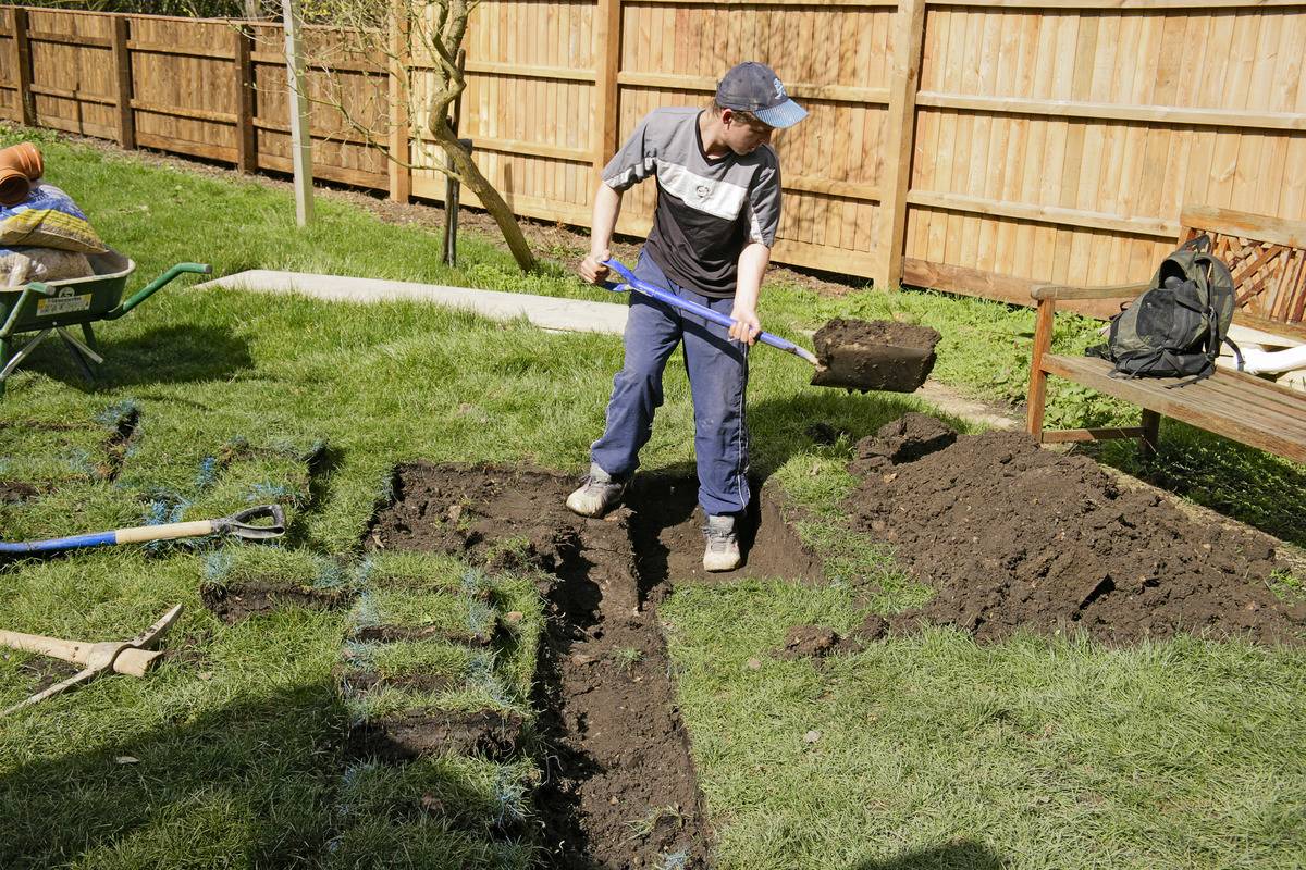 A gardener digs a trench to drain his garden.