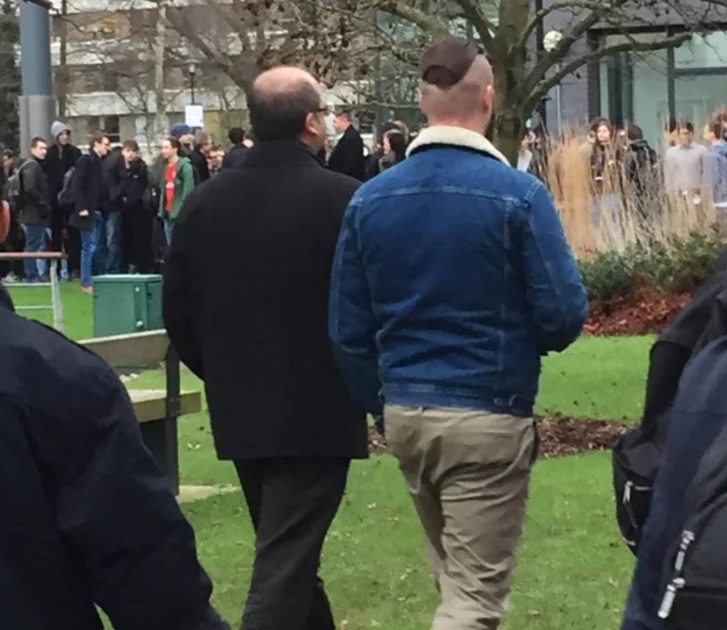 man with head shaved on sides next to man with hair only on sides