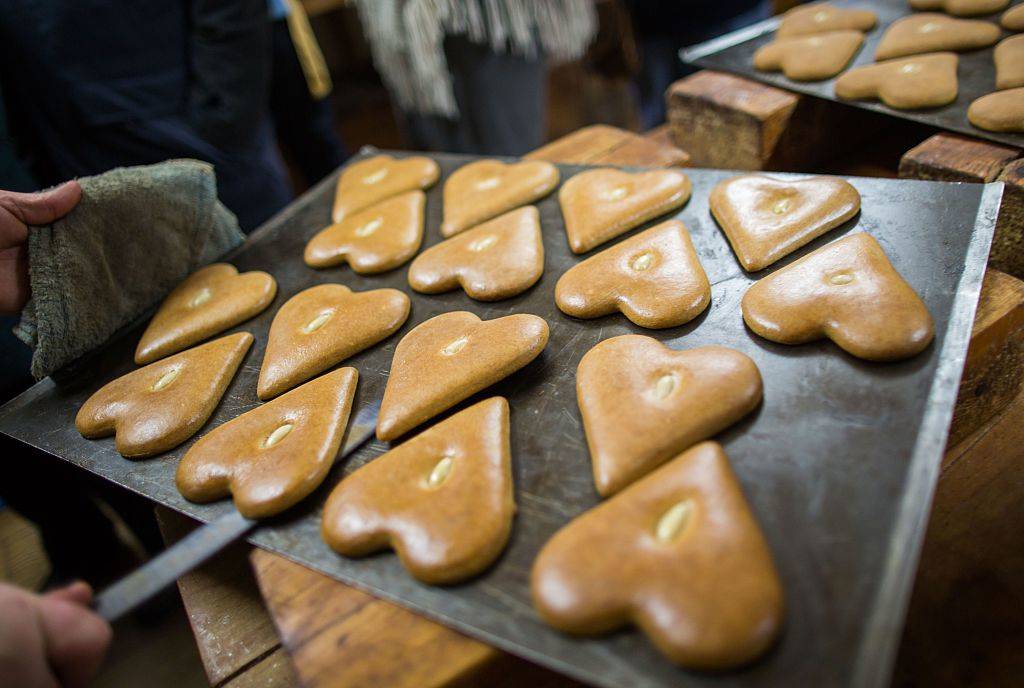 Freshly baked gingerbread hearts lay on a baking sheet