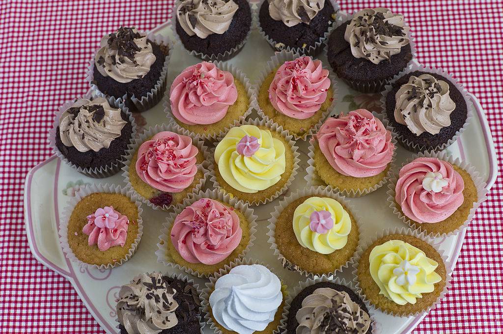 yellow, pink, and chocolate cupcakes on a plate