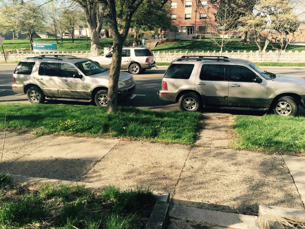 three of the same car parked in the same place on the same street