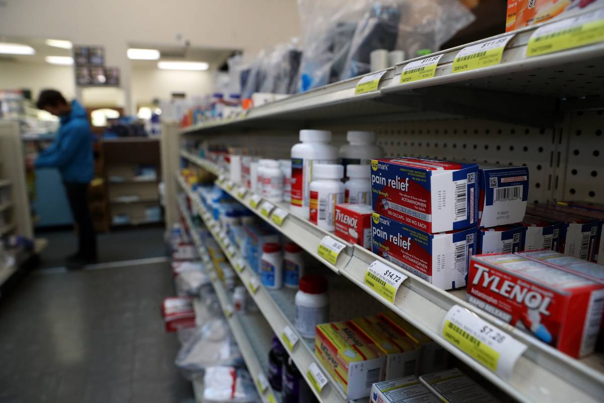 Acetaminophen are displayed on a shelf at a pharmacy.