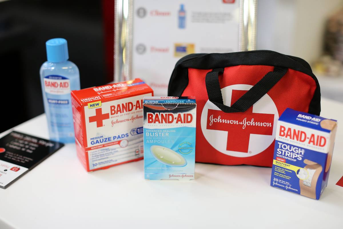 A first aid kit sits next to several different packages of Band-Aids.