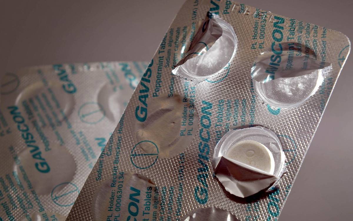 A package of anti-acids has some pill slots popped open.