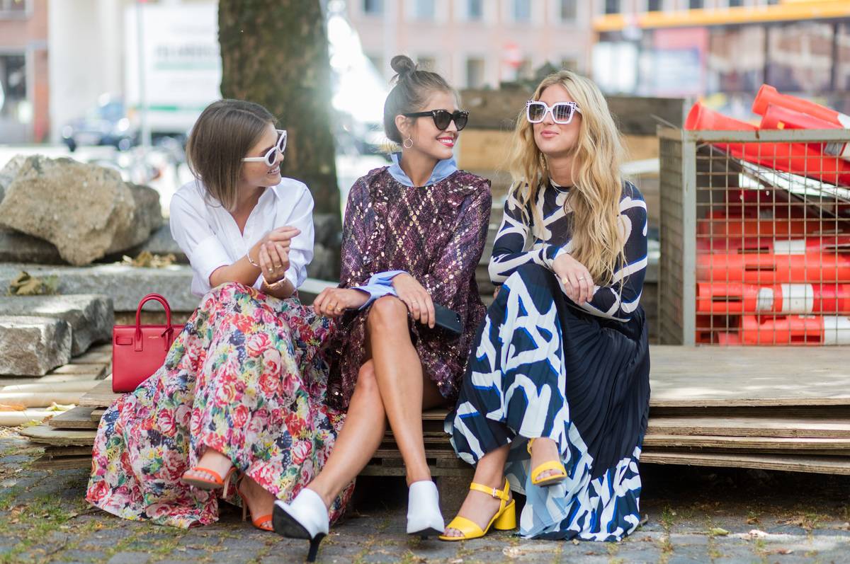 girls sitting on street edge talking