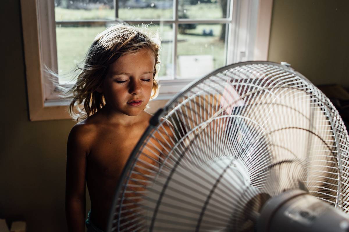 Girl standing in front of fan